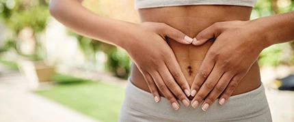 Frau hält sich die Hände vor den Bauch